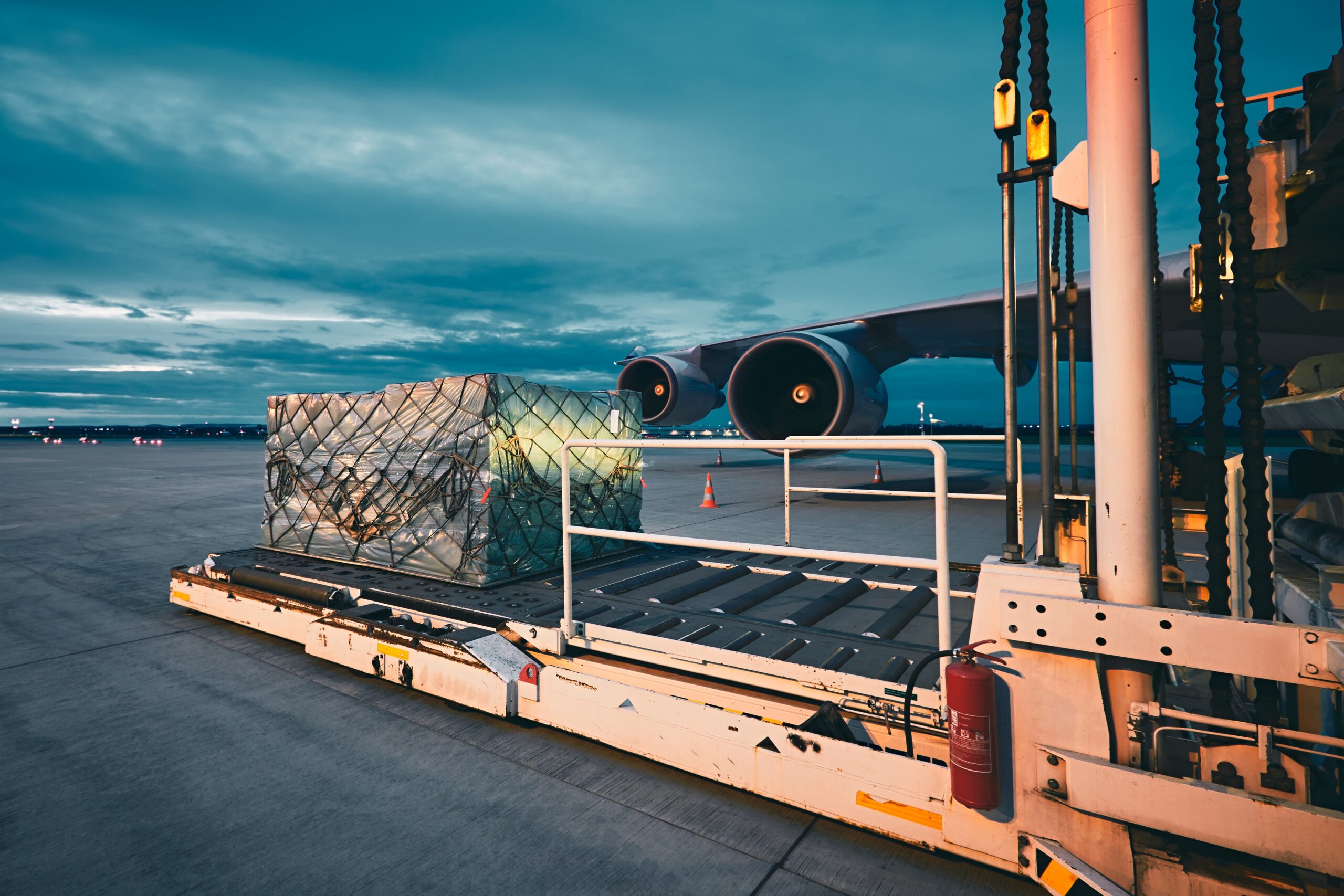 Airport at the dusk. Loading of cargo to the freight aircraft.
